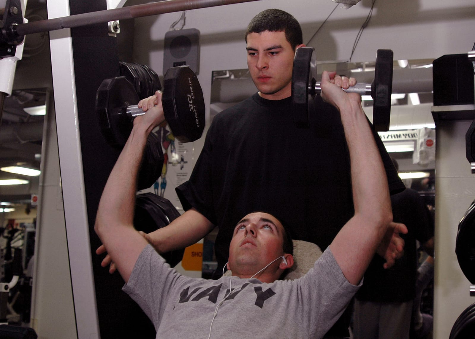 Incline dumbbell press near mid-to-lockout on a ship gym bench.