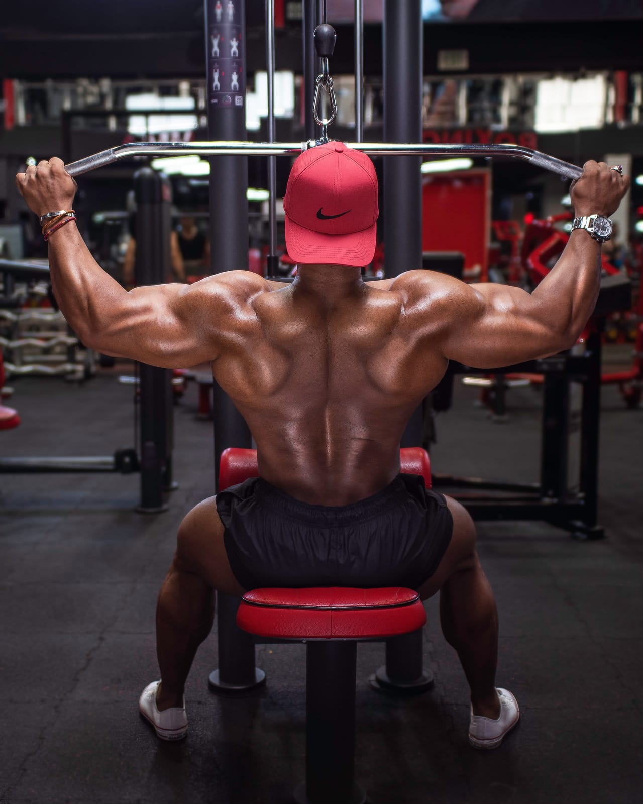 Rear view of a seated wide-grip lat pulldown in mid-range.