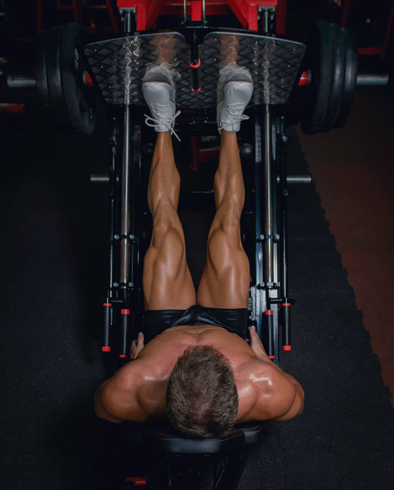 Athlete on a plate-loaded sled leg press near lockout.