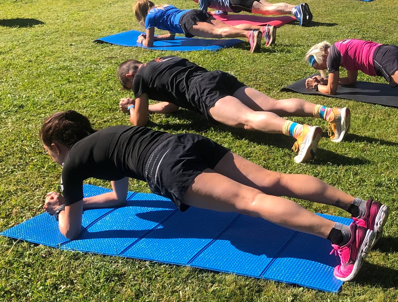 Outdoor class photograph of forearm planks.